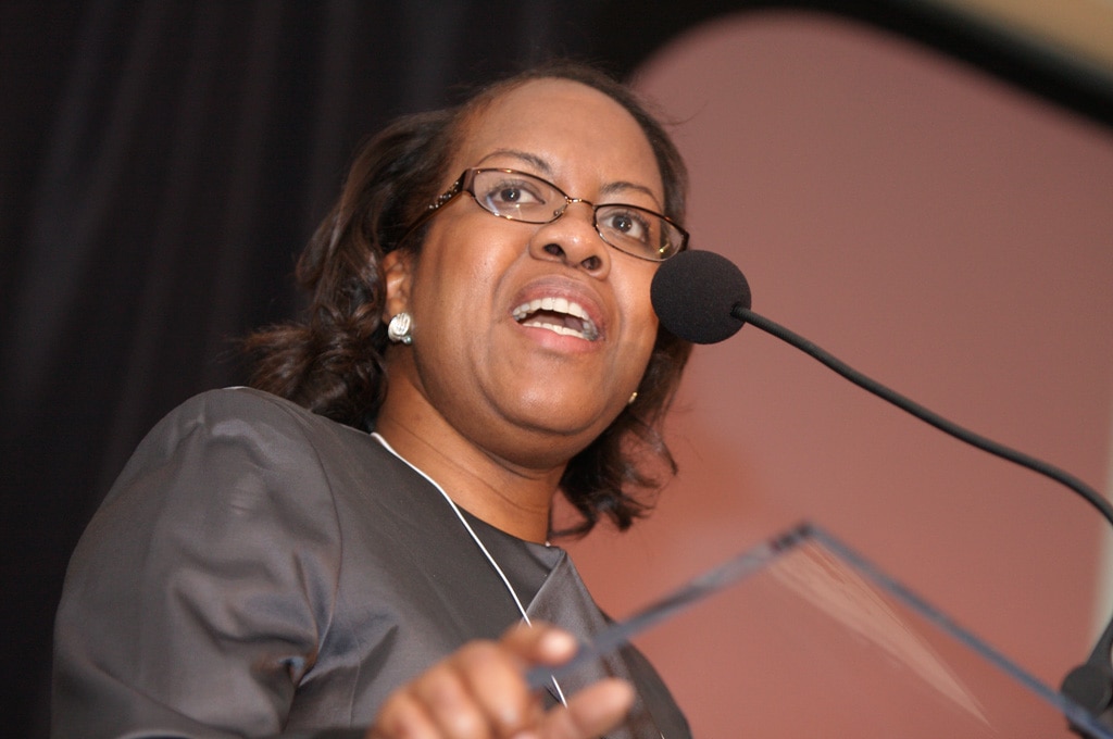 Monica Parham speaking into a microphone at a podium.