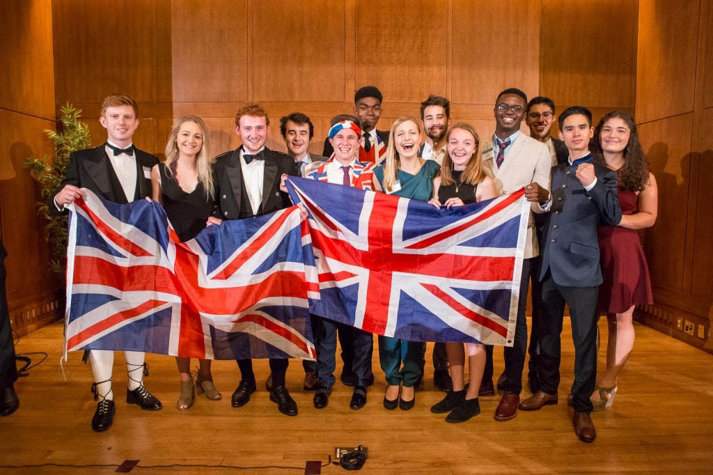 A group of British scholars hold patriotic flags at the Fall Banquet