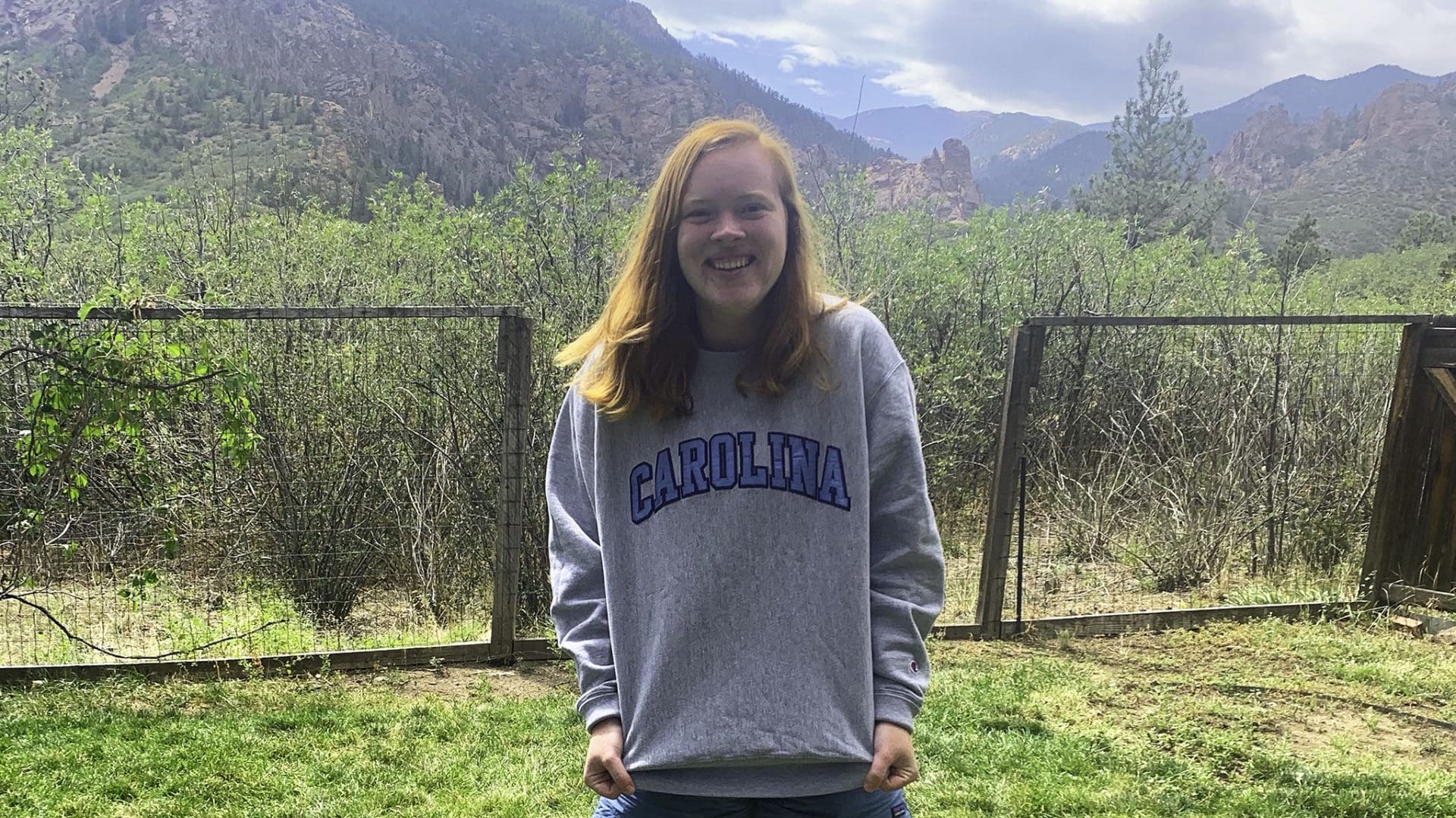 Virginia Griffin ’23 smiling and sporting a Carolina sweatshirt in front of some mountains in Colorado.