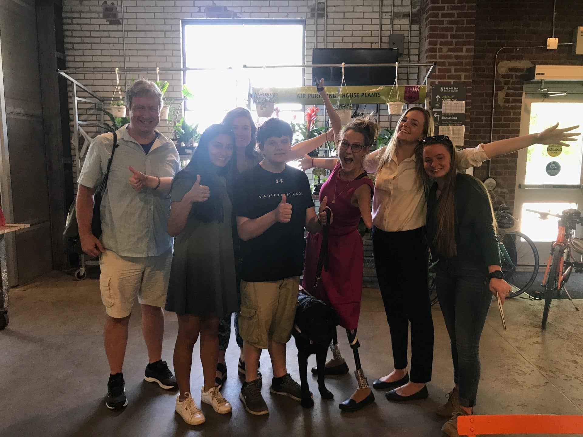 Group of people smile for the camera inside Evergreen Brickworks.