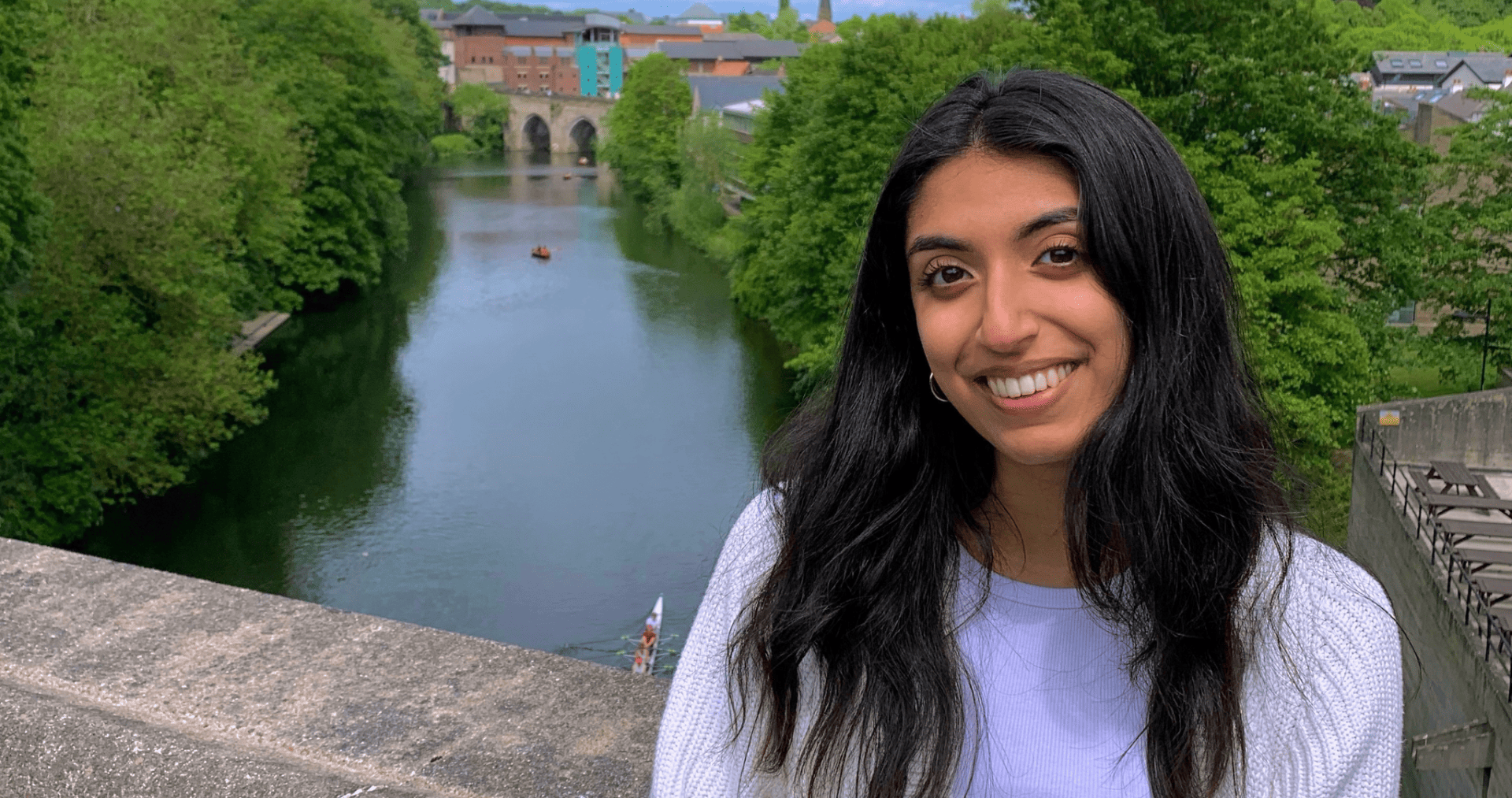 Neha Saggi ’25 sitting on a bridge next to a river
