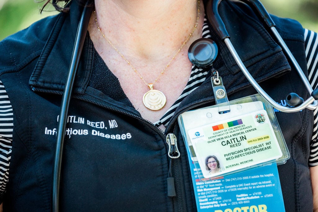 Close-up of Caitlin Reed wearing her hospital credentials and medical gear.