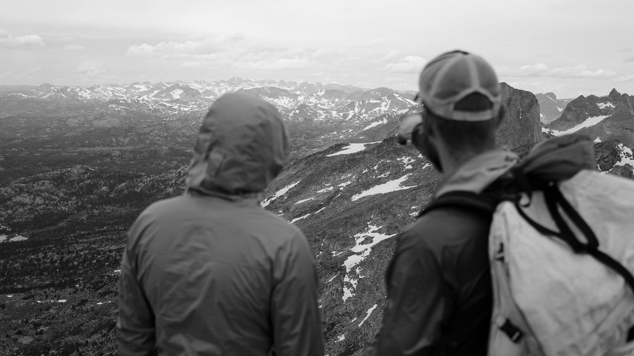 Two people admiring a mountainous landscape.