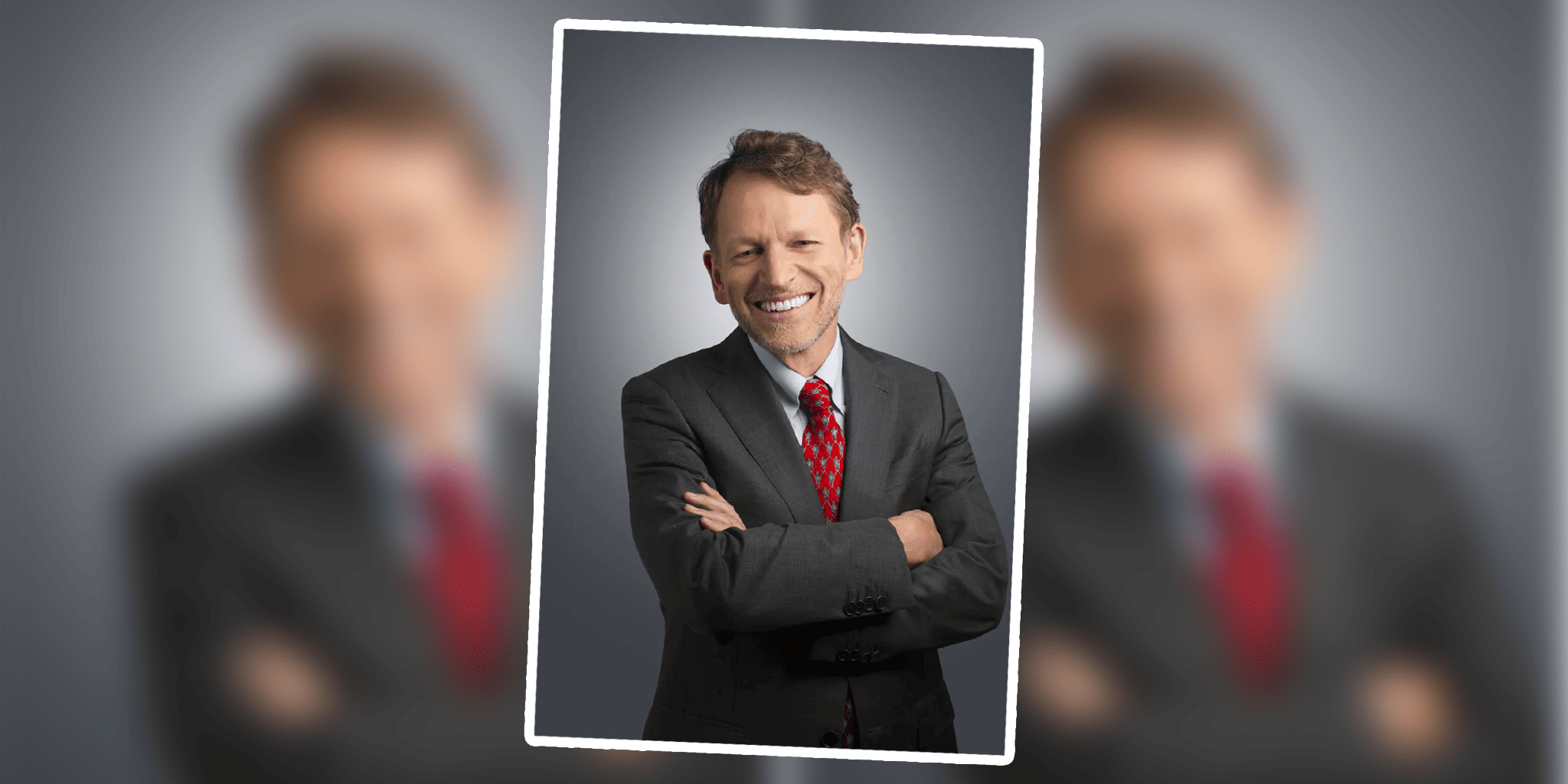 David Royale in a suit and tie smiling.