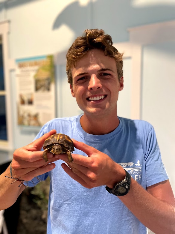 Michael holds a small turtle. 