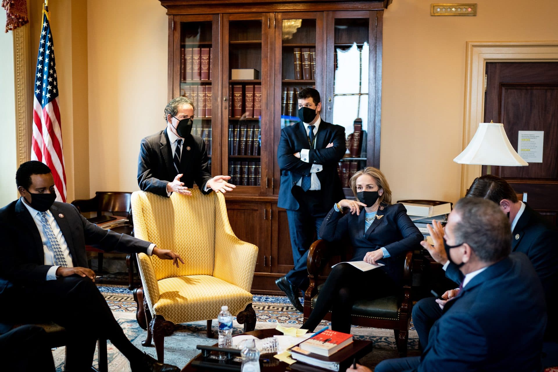 Aaron Hiller ’03, center, with other members of the U.S. House Committee on the Judiciary sit speaking to one another in a government office.