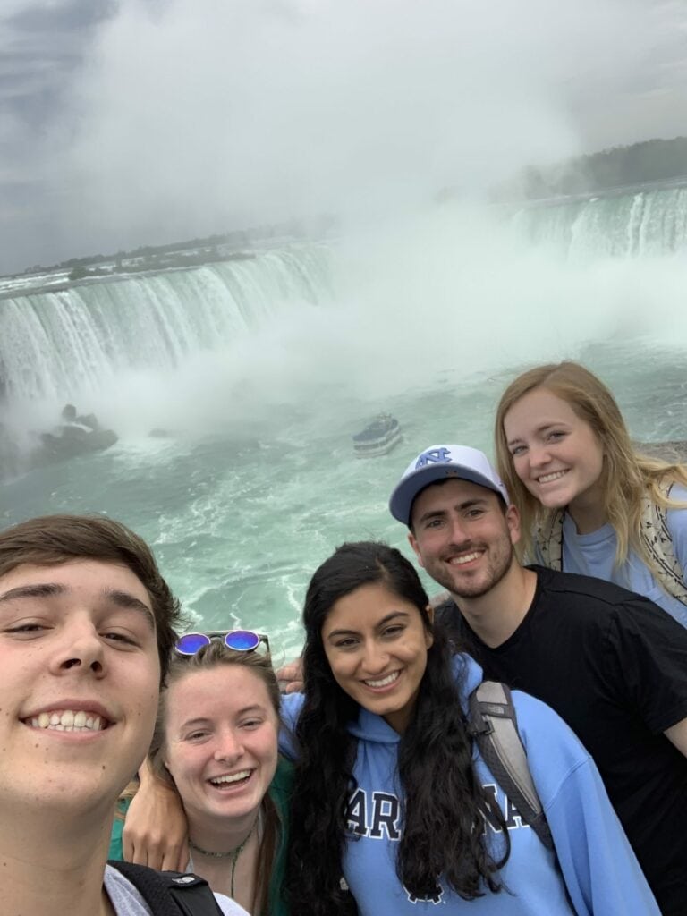 Five scholars smile for the camera with the Niagara Falls in the background.