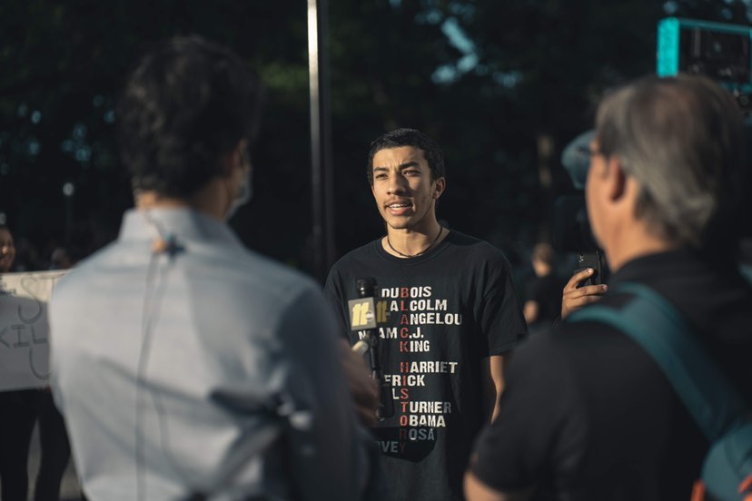 Greear Webb talks to reporters at a protest.