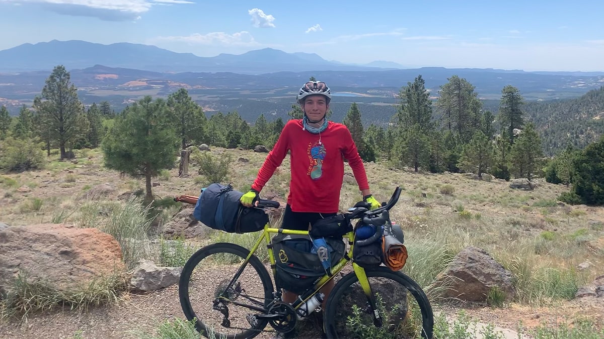 Photo of Emmaus Holder ’23 standing behind his bike.