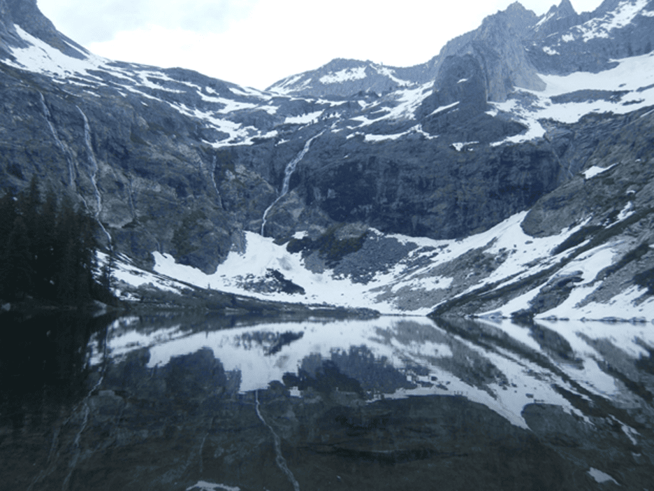 View of an icy lake surrounded by snowy mountains.
