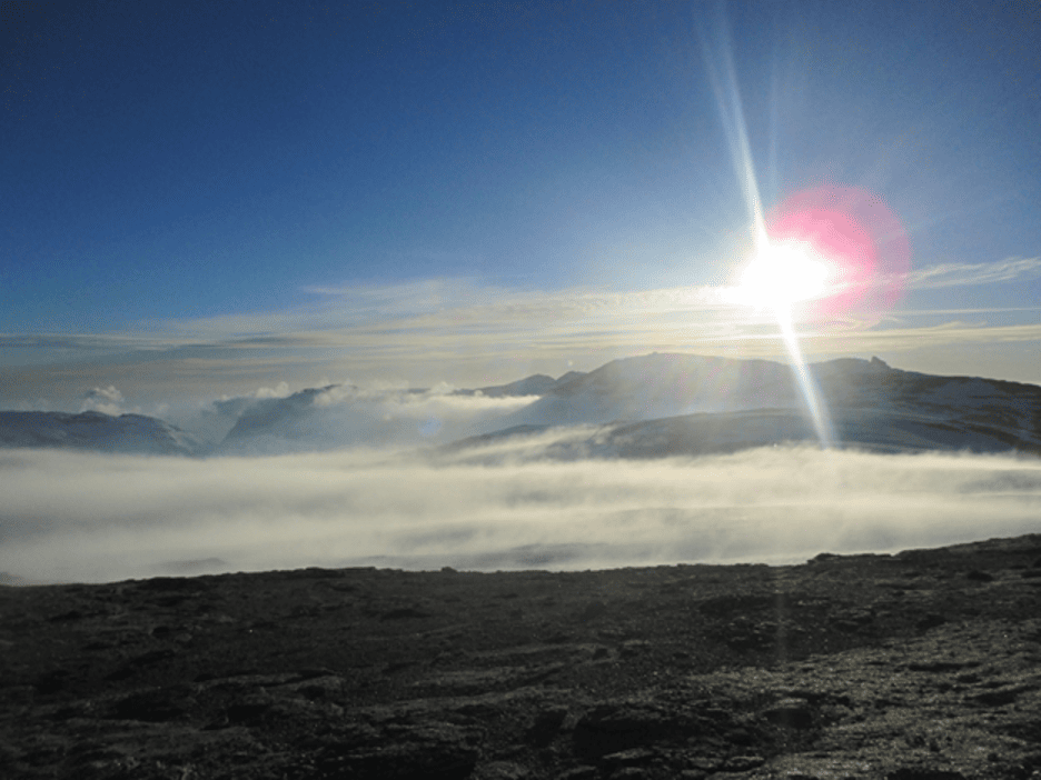 Landscape view of mountains and clouds on a sunny day.