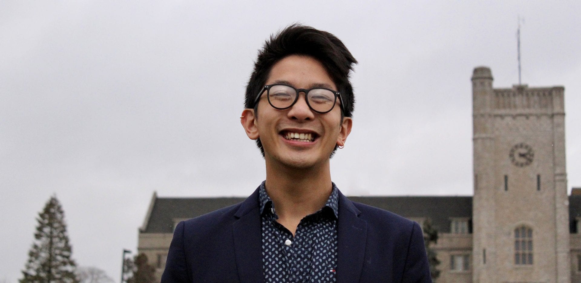 Raymond Tu wearing glasses and smiling.
