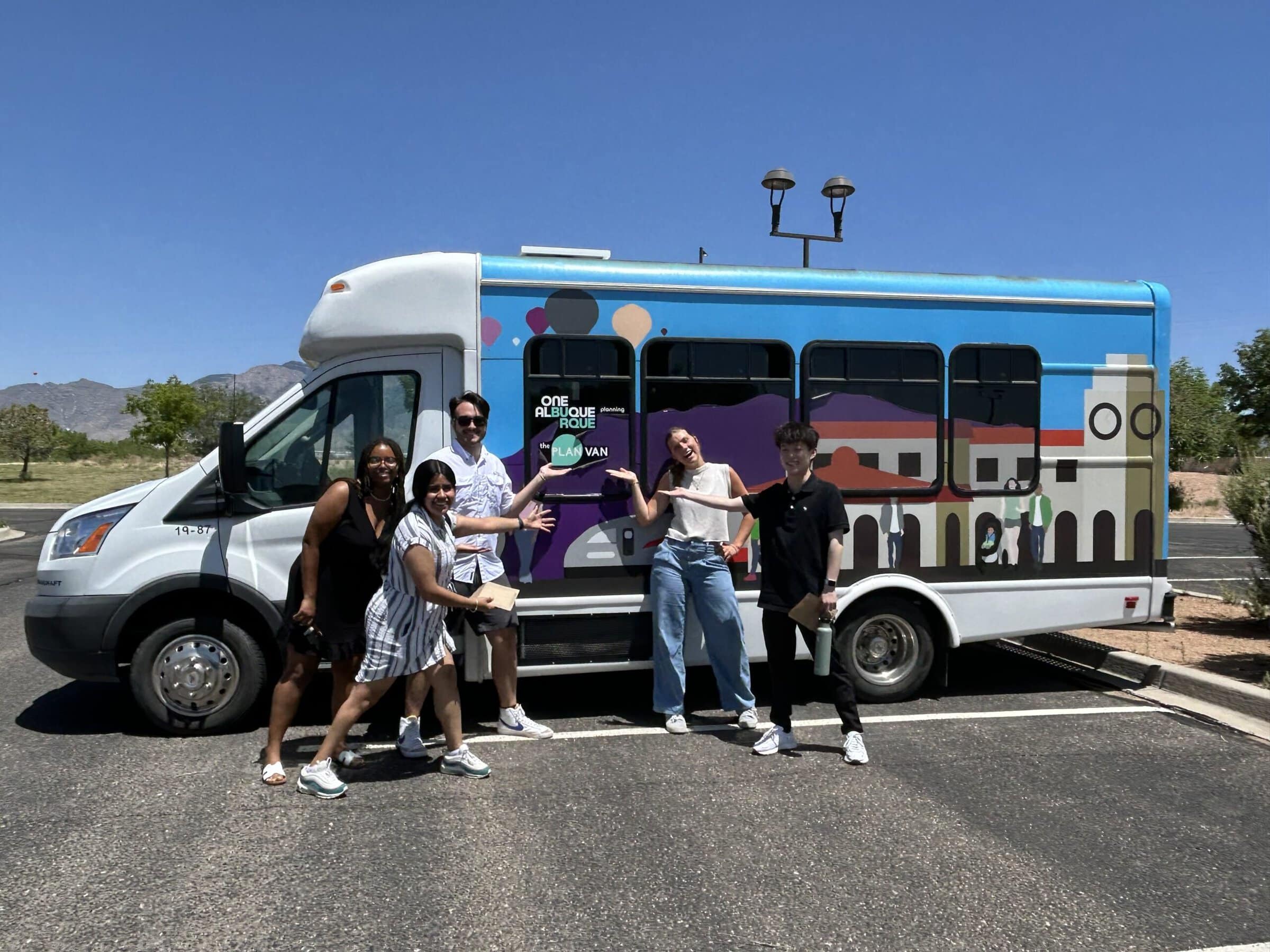 A group of scholars standing next to a City of Albuquerque's vehicle.