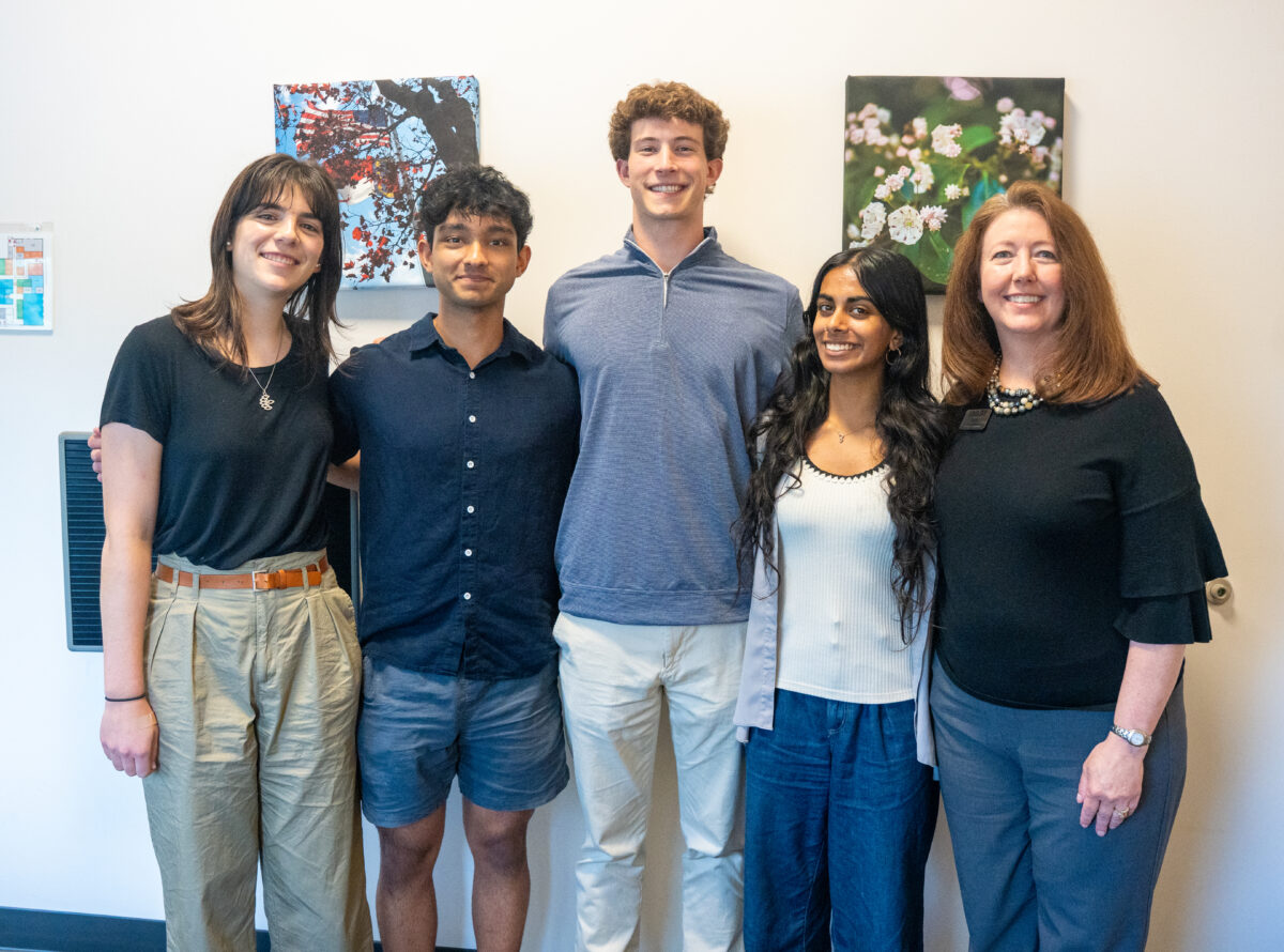 Four Morehead-Cain scholars and one adult smile together at the Land of Sky Regional Council office.