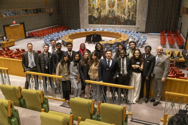 Global Fellows and Ousley Naseman stand together in the United Nations building.