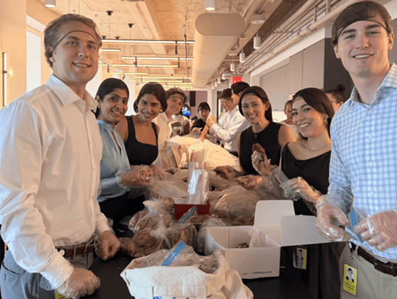Benji Garland ’27 and fellow summer interns wear gloves and package leftover food for delivery to Publicolor in New York City. The interns also repackaged leftover food from nearby restaurants for delivery to Publicolor in New York City.