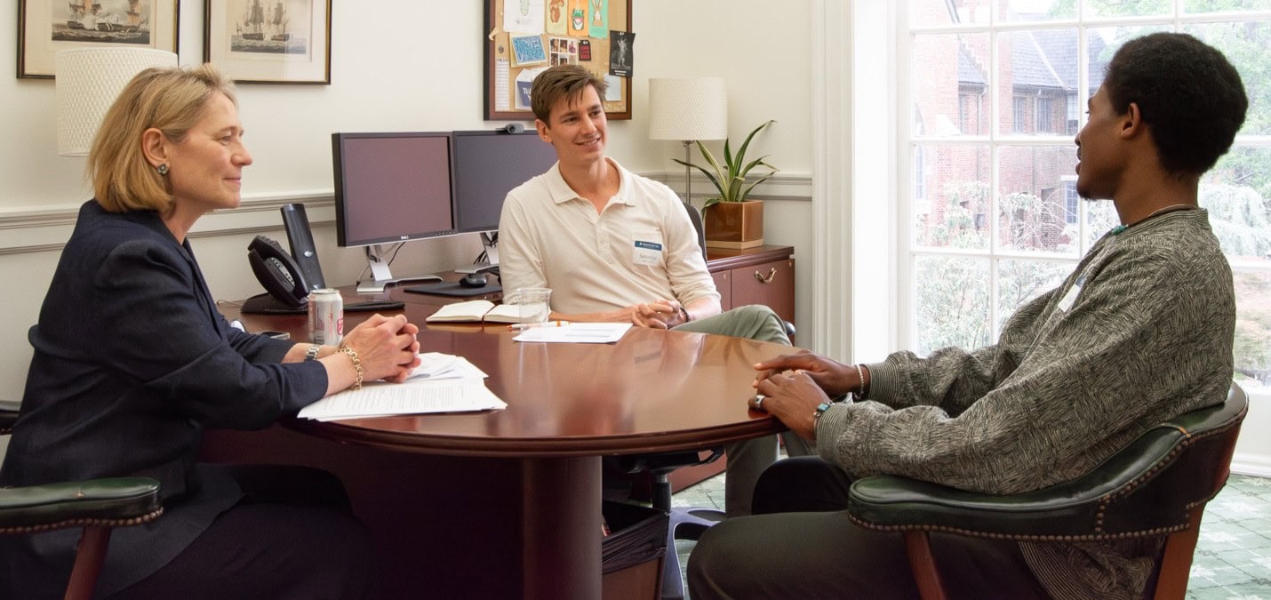 People talking around an office desk.